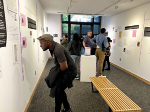 A crowd studies the exhibit “Sweeter Than the Onions: Stories of Queer Resilience in Walla Walla,” at Whitman College. (Credit: Courtney Flatt, Northwest News Network)