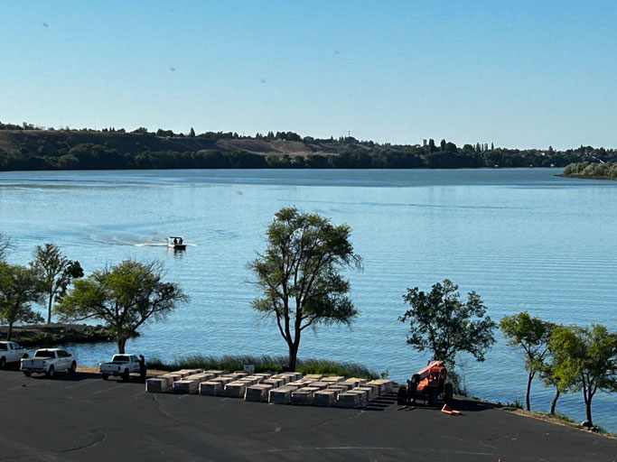 A blue sky over Moses Lake reflects making the entire lake look blue from the lakeside.