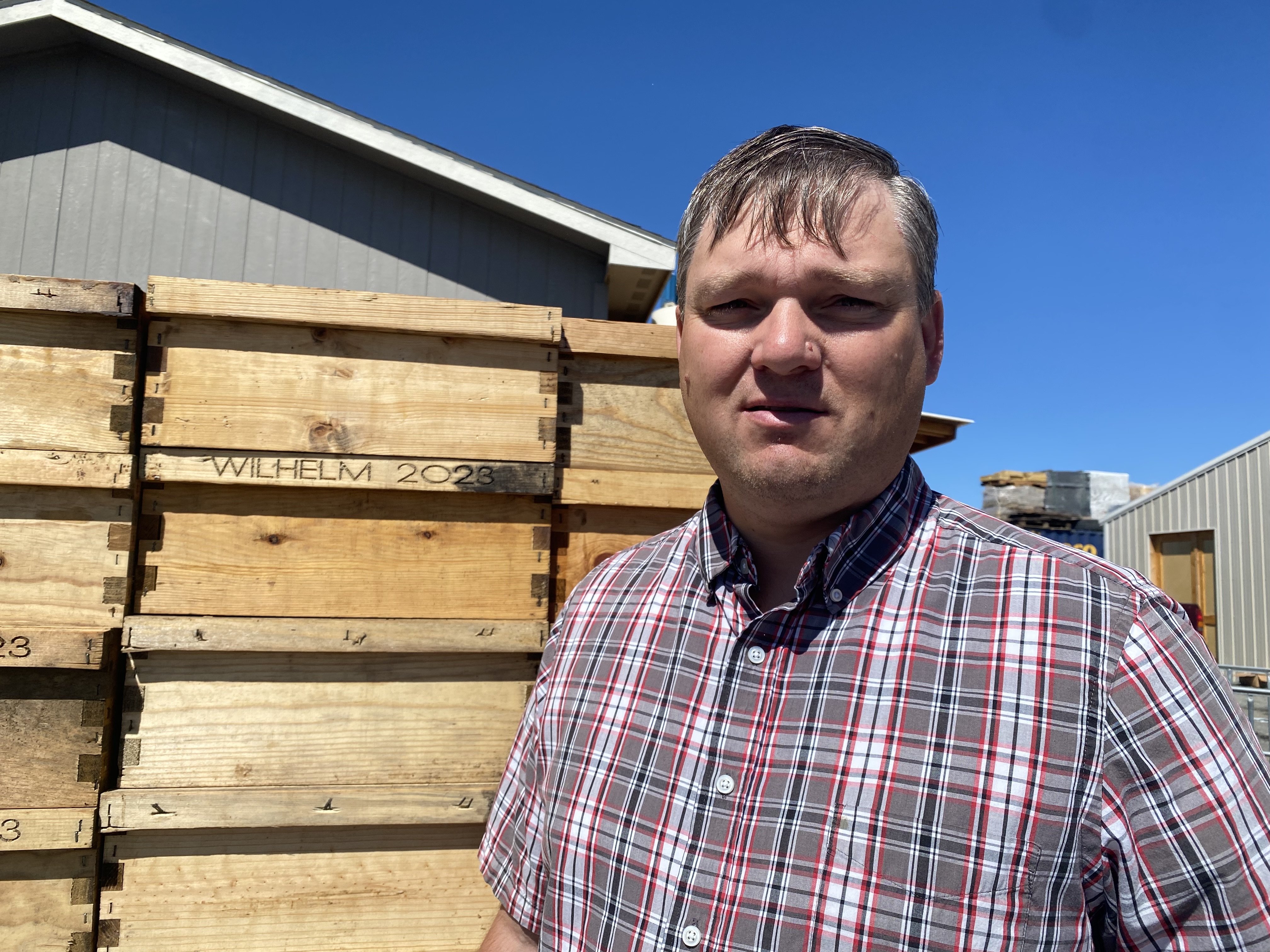 Bud Wilhelm stands in front of some new bee boxes on Monday constructed on his farm in Royal City, Washington.