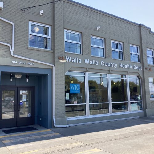 A tan building with big windows is pictuted.