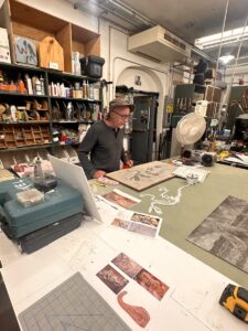 David Miller stands over his work table in the basement of the Whatcom Museum. Here he works on items for the exhibits upstairs, as well as his work as a scientific illustrator. (Credit: Lauren Gallup / NWPB)