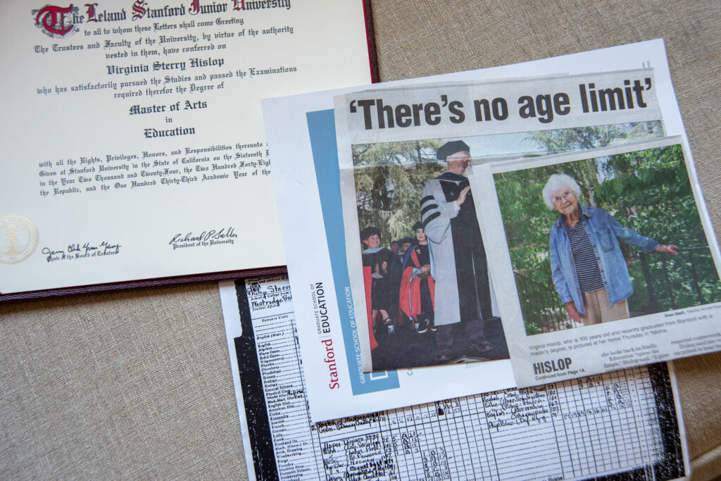 A close up picture of newspaper clippings and a college degree.