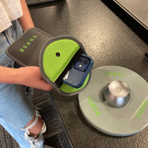 A student holds her phone pouch over the Yondr magnet.