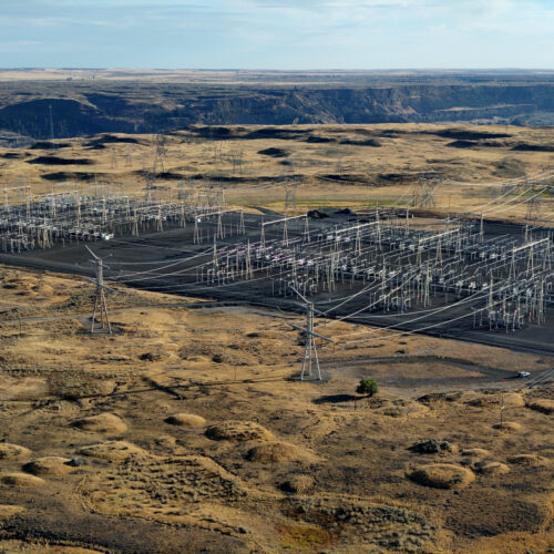 Large electrical transmission equipment is in a brown square. Shrub-steppe habitat surrounds the equipment.