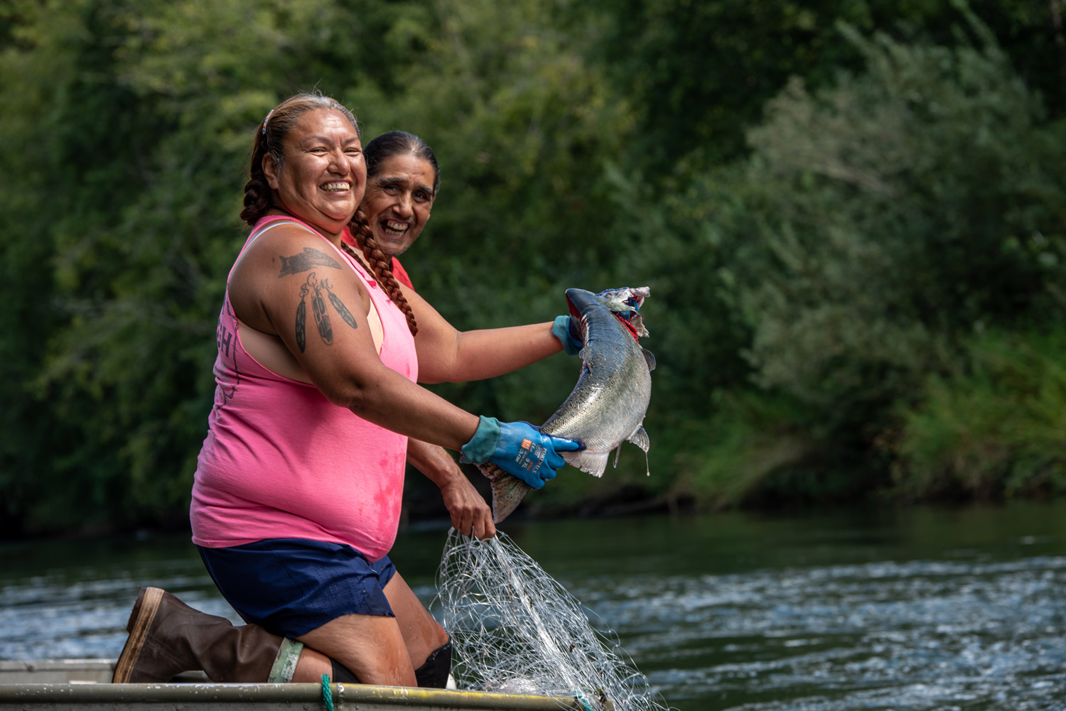 a woman holds a fish in a boat