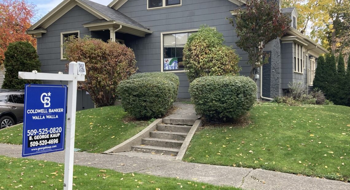 A blue house with a "for sale" sign in Walla Walla.