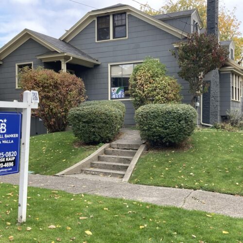 A blue house with a "for sale" sign in Walla Walla.