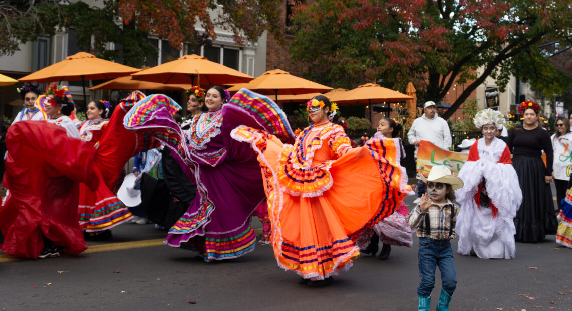 Dancers in colorful dresses walk in a parade