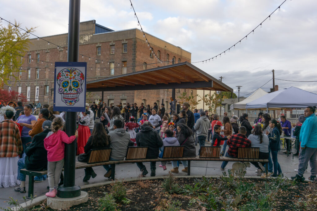 People gathered in a square watching a mariachi band