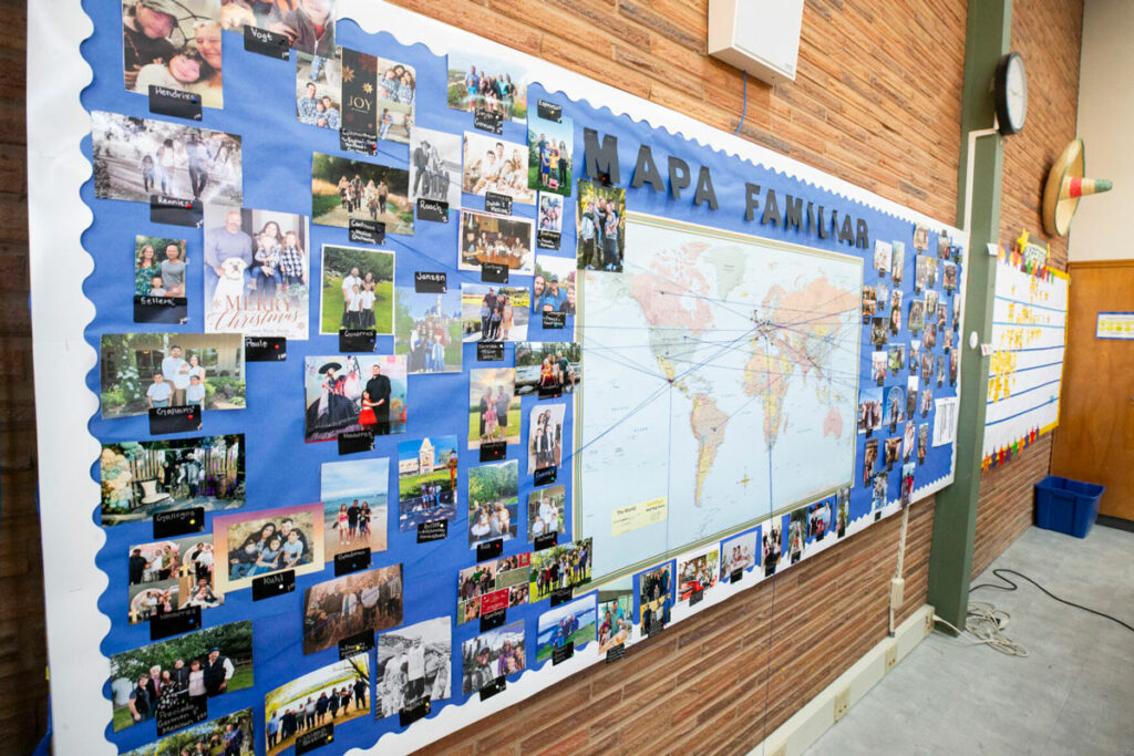 A world map is on display. Around it, pictures of people are attached.