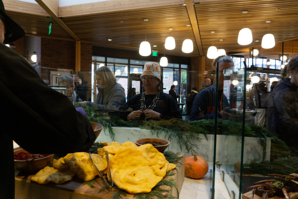 A woman in Native dress waits for a serving of fry bread.