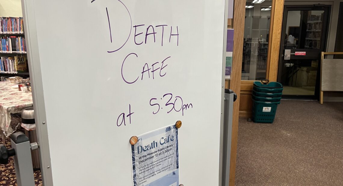 A whiteboard with the words "Death Cafe at 5:30 PM" is on display at a library.