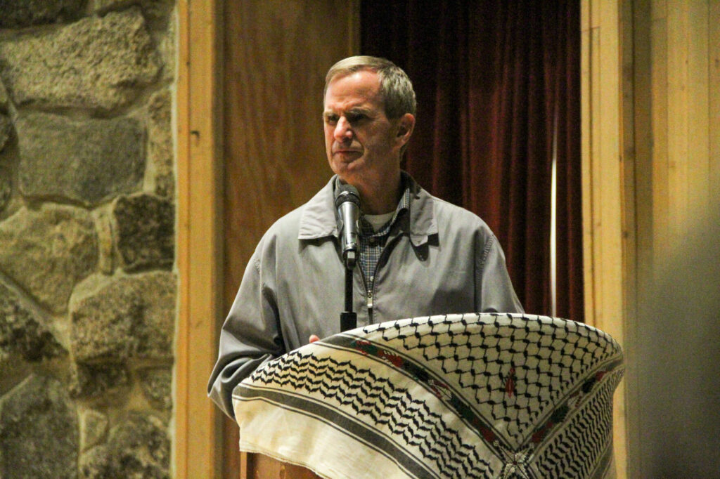 Carl J. Florea, Leavenworth's mayor, stands behind a podium with a microphone.