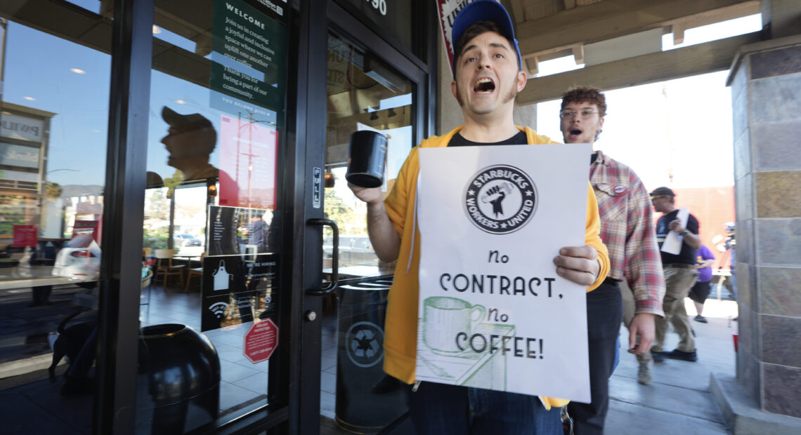 Starbucks workers picket outside of a closed Starbucks on Friday, Dec. 20, 2024, in Burbank, Calif. After the largest strike from the company in it's history, workers have yet to reach a collective bargaining agreement with Starbucks.(AP Photo/Damian Dovarganes)