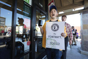 Starbucks workers picket outside of a closed Starbucks on Friday, Dec. 20, 2024, in Burbank, Calif. After the largest strike from the company in it's history, workers have yet to reach a collective bargaining agreement with Starbucks.(AP Photo/Damian Dovarganes)