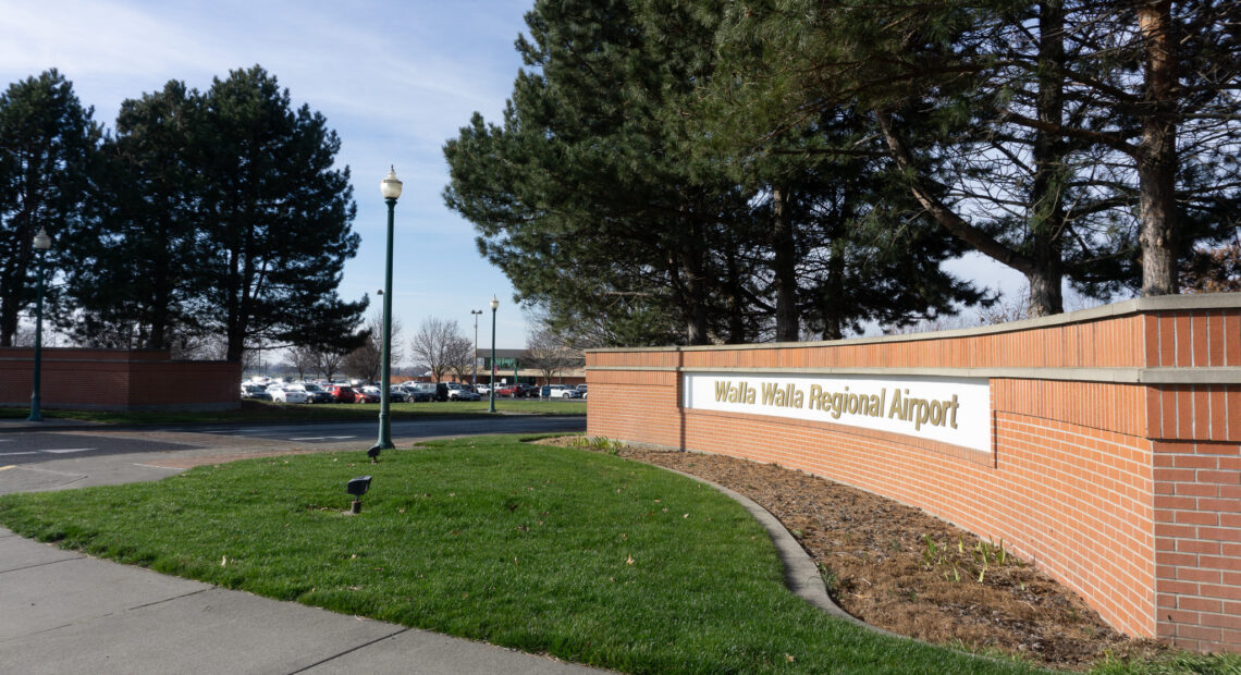 A brick wall leads into a parking lot. The sign reads "Walla Walla Regional Airport"