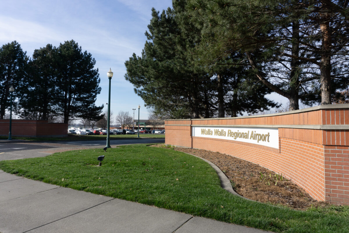 A brick wall leads into a parking lot. The sign reads "Walla Walla Regional Airport"