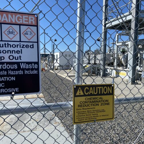 A gate and signs stand guard at one of the Hanford site’s tank farms.