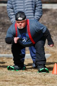 Jeff Greene stands in a blue shirt and black pants at the starting line of a track in Salt Lake City. 