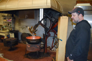 Bill Johnson stands in the upstairs room where he makes candy at the Johnson Candy Company. The copper fire mixer to his left is the same one his grandfather used.