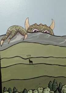 A green monster with horns and white talons leers over green hills as the small shadow figure of a coyote looks up at him. 