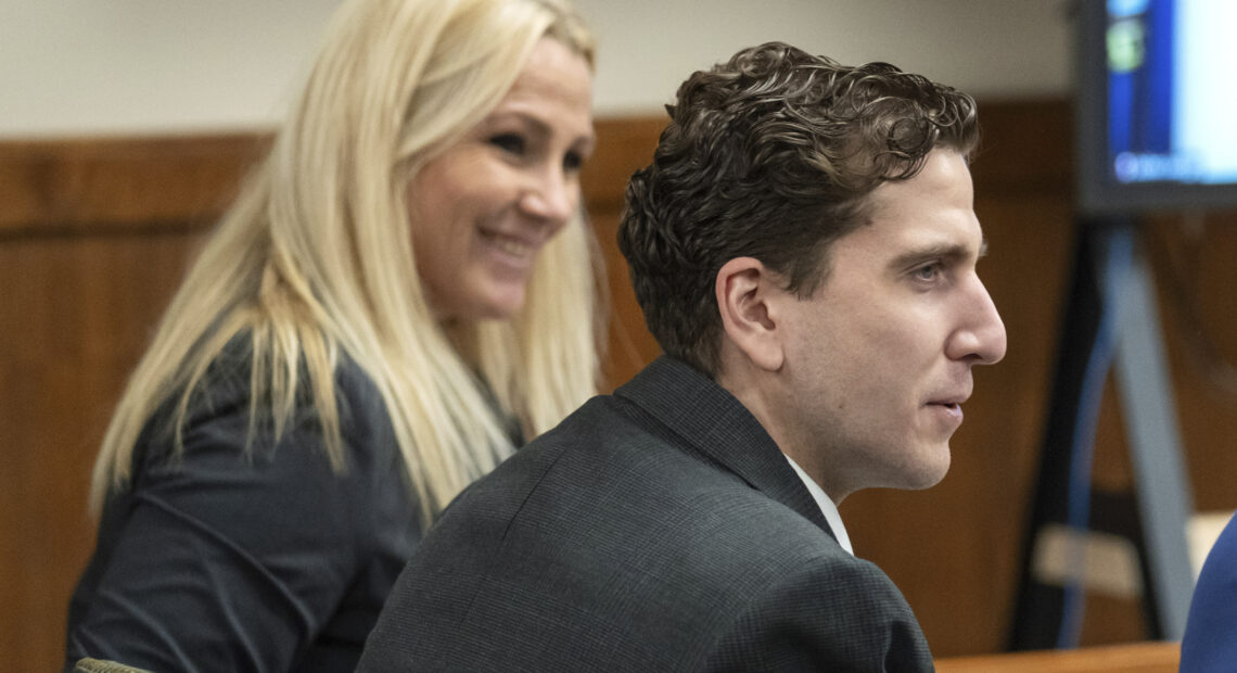 Bryan Kohberger wears a grey suit and sits next to his attorney Anne Taylor, who also wears a grey suit and has blonde hair, in a Latah County Courtroom.