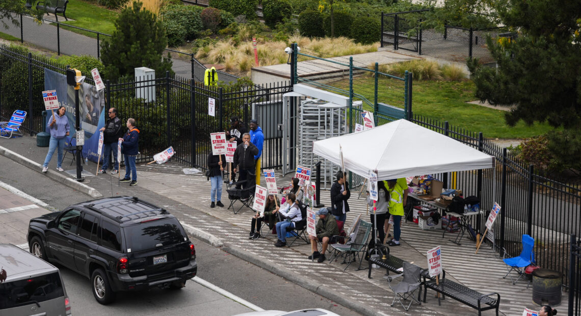 Boeing workers wave picket signs at passing cars as they strike Tuesday, Sept. 24, 2024, near the company's factory in Renton, Wash. If Washington state passes the proposed legislation, striking workers, after a waiting period, could receive unemployment benefits. (AP Photo/Lindsey Wasson)