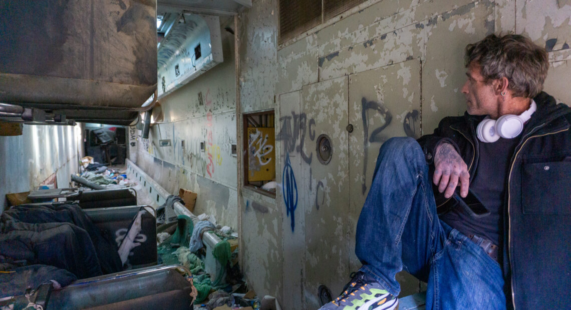 A man looks into an abandoned rail car