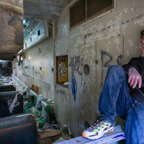 A man looks into an abandoned rail car