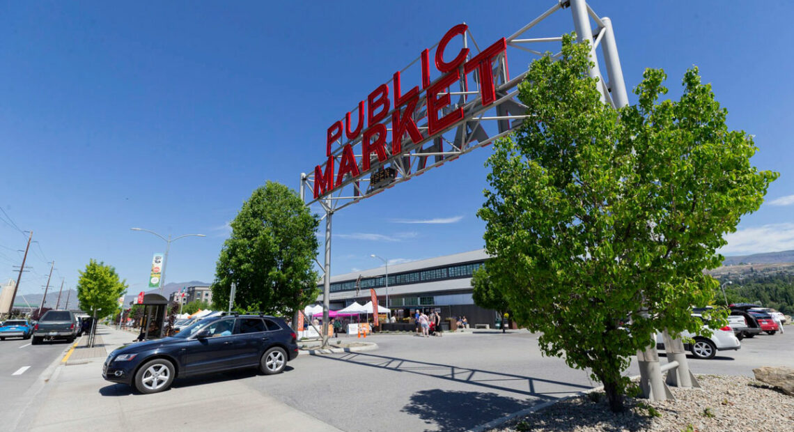 Pybus Market in Wenatchee, Washington. A car drives by. The sky is blue.