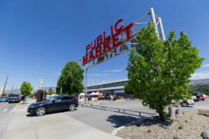 Pybus Market in Wenatchee, Washington. A car drives by. The sky is blue.