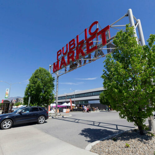 Pybus Market in Wenatchee, Washington. A car drives by. The sky is blue.