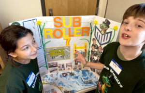 Fourth grader Viviana Vargas and fifth grader Dylan Gurtisen present their plans for the Sub Roller 7, a robot the team designed to help chew up an overabundance of stargrass in the Yakima River. (Credit: Courtney Flatt / NWPB)