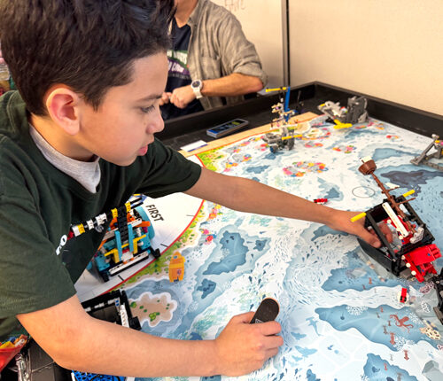 Fourth grader Sergio Preciado shows off a Lego shipwreck he helped build and code with his FIRST Lego League team, called the Dino Nuggys. The program is mostly grant funded through the Washington Office of Superintendent of Public Instruction. (Credit: Courtney Flatt / NWPB)